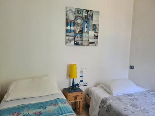 - une chambre avec 2 lits et une photo sur le mur dans l'établissement La casa di Nataly, à Fregene