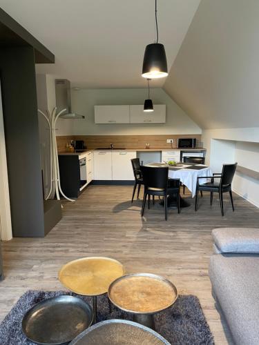 een woonkamer met een tafel en stoelen en een keuken bij Appartements de Manon au cœur des vignes in Kientzheim