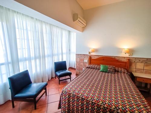 Habitación de hotel con 1 cama y 2 sillas en Hotel Can Solé en Cambrils