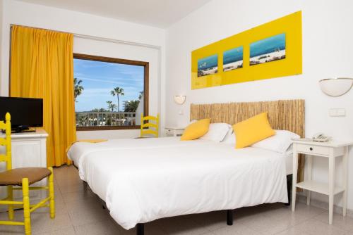 1 dormitorio con 2 camas, escritorio y ventana en Villa Miel, en Cala Millor