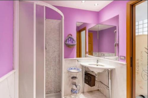 a purple bathroom with a sink and a mirror at LuMia in Aci Castello