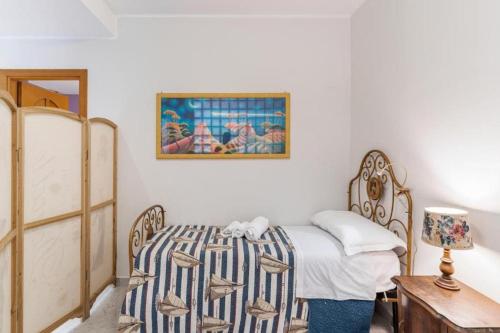 a bedroom with a bed and a painting on the wall at LuMia in Aci Castello