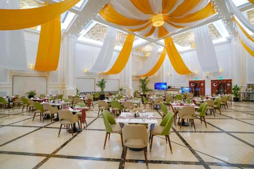 a banquet hall with tables and chairs in a building at La Maison Hotel Doha in Doha
