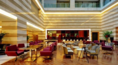 a restaurant with tables and chairs in a building at Shenzhen The Bauhinia Hotel, Mix City Shopping Center in Shenzhen