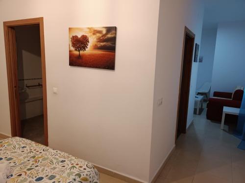 1 dormitorio con una foto de un árbol en la pared en Apartamento bajo en Mentidero, en Cádiz