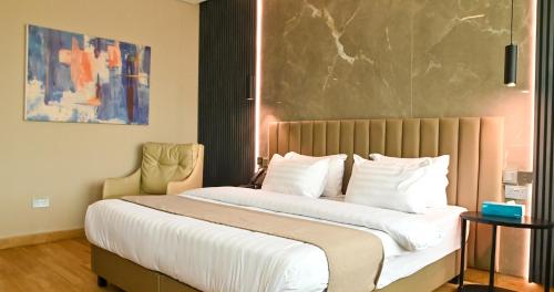 a hotel room with a large bed with white pillows at Vertigo Hotel in Lagos