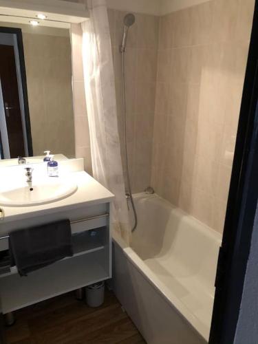 une salle de bain avec un lavabo et une baignoire et un lavabo dans l'établissement Chalet 4 pers. Piscine et literie toute neuve., à Puy-Saint-Vincent