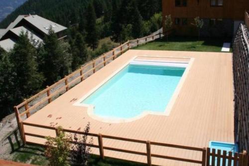 una terrazza in legno con vista sulla piscina. di Chalet 4 pers. Piscine et literie toute neuve. a Puy-Saint-Vincent