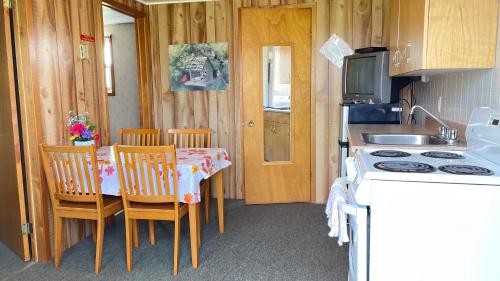 a kitchen with a table and chairs and a stove at Rachel's Motel and Cottages in Surrey
