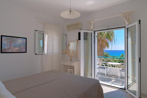 1 dormitorio con cama y vistas al océano en Vivian Apartments, en Vlachata
