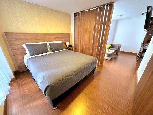 una camera con un grande letto e un pavimento in legno di Cómodo Apartaestudio en super ubicación a Bogotá