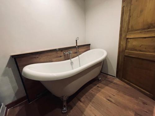 a bath tub in a bathroom with a wooden door at Appartement Sabrina in Steinberg am Rofan