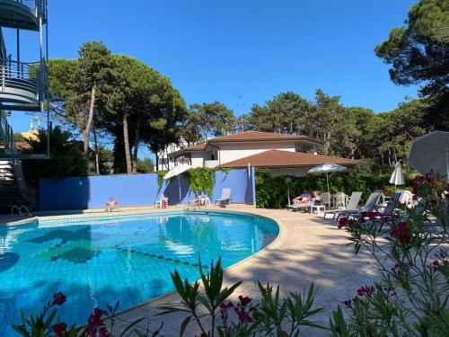 einen Pool in einem Resort mit Stühlen und Bäumen in der Unterkunft Hotel Alemagna in Bibione