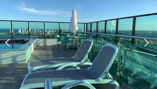 een balkon met stoelen en een tafel op een schip bij Flat Lindo e Aconchegante in Recife