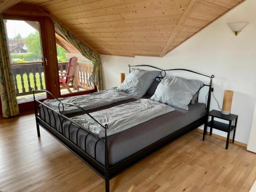 a bedroom with a bed in a room with a balcony at Bergblick in Weilheim in Oberbayern