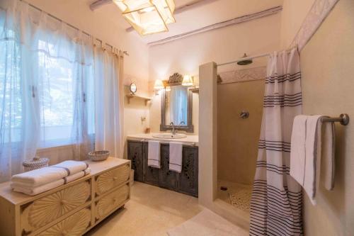 a bathroom with a shower and a sink and a mirror at DIAMOND HAVEN in MALINDI in Malindi