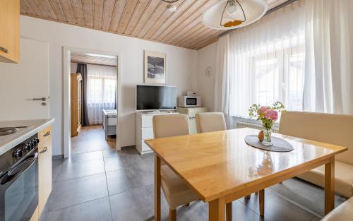 eine Küche und ein Wohnzimmer mit einem Holztisch und einem Esszimmer in der Unterkunft Ferienwohnung Schnappenblick in Grassau
