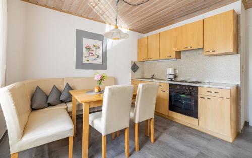 eine Küche mit einem Tisch und Stühlen sowie ein Esszimmer in der Unterkunft Ferienwohnung Schnappenblick in Grassau