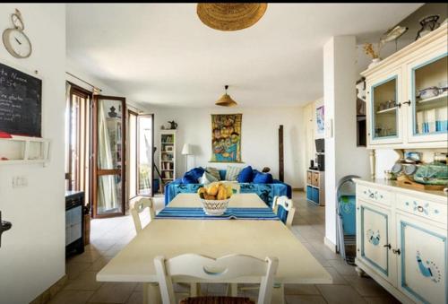 a kitchen with a table and a blue couch at Corbezzolo in Funtana Meiga