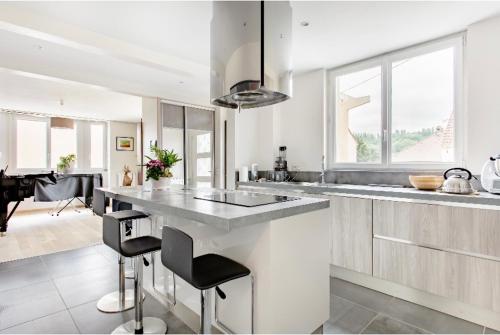 ラ・フェルテ・スー・ジュアールにあるChambre a la Ferteの白いキッチン(大きなカウンター、いくつかの椅子付)