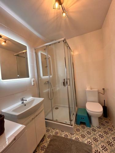 uma casa de banho com um chuveiro, um lavatório e um WC. em I - Apartament na Warmi dla rodzin z dziećmi em Gietrzwałd