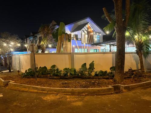 a house at night with a fence and trees at The Viista Retreat 6 Bedrooms with Private Pool in Johor Bahru