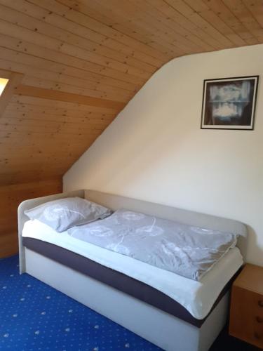 Bett in einem Zimmer mit Holzdecke in der Unterkunft RD Černčín Bučovice in Černčín