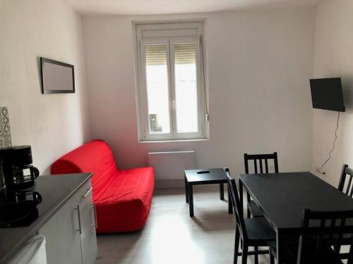 un salon avec une chaise rouge et une table dans l'établissement Studio meublé à 700 m de la plage, à Berck-sur-Mer