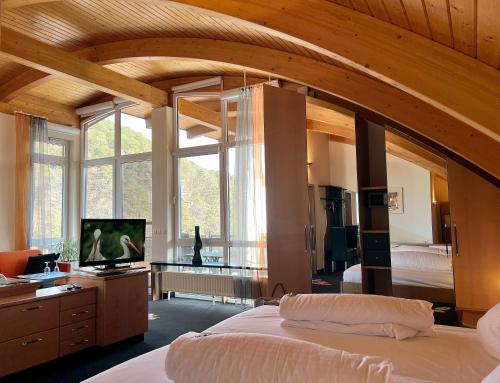 ein Schlafzimmer mit großem Bett und großem Fenster in der Unterkunft Hotel Am Hirschhorn - Wellness - Spa - and more in Wilgartswiesen