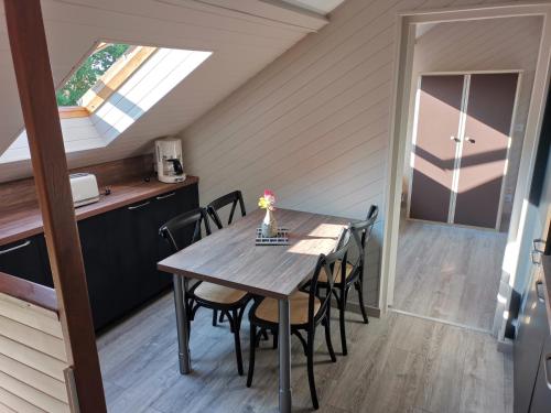 een keuken en eetkamer met een tafel en stoelen bij Le manège Gite L'Eglise in Sainte-Marie-au-Bosc