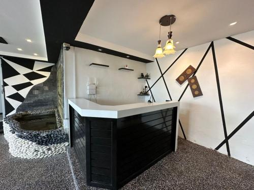 een badkamer met een zwart-witte wastafel en een trap bij Kuu Inn Motel in Arau