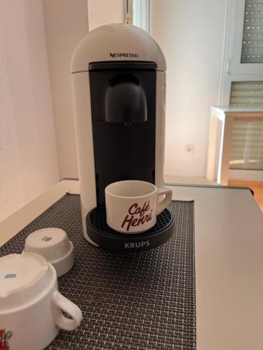 eine Kaffeemaschine und eine Tasse auf der Theke in der Unterkunft Kosly garden Robertsau in Straßburg