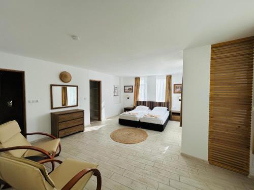 Apolonia Apartments في سوزوبول: غرفة معيشة فيها سرير وكراسي
