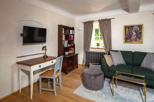 a living room with a green couch and a desk at Podenhaus in Bad Aussee
