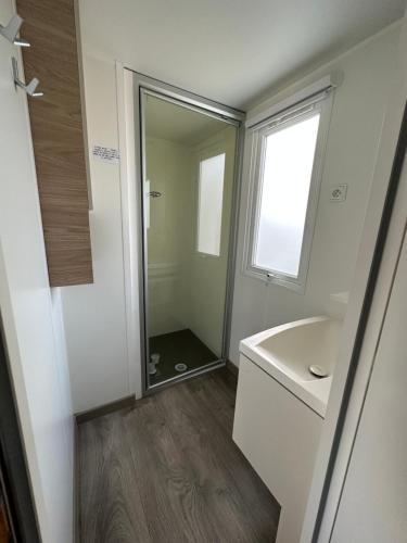 une salle de bain avec une douche, un lavabo et un miroir dans l'établissement Les sables chal’heureux, à Saint-Jean-de-Monts