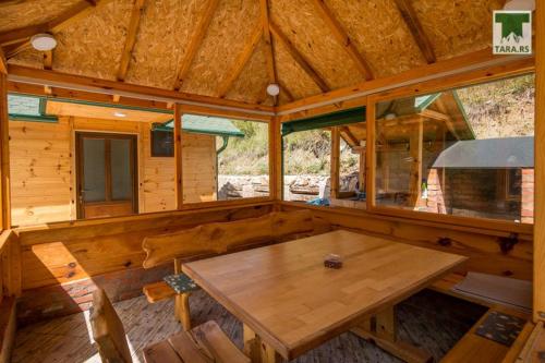 une grande chambre en bois avec une table en bois dans une cabine dans l'établissement Air Zaovine, à Bajina Bašta