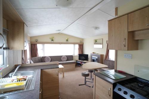 eine Küche und ein Wohnzimmer eines Wohnwagens in der Unterkunft Manor at Manor Park Hunstanton WiFi pets go free in Hunstanton
