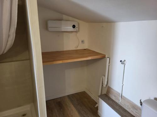 Elle comprend une petite salle de bains pourvue de toilettes et d'une étagère. dans l'établissement Appartement au 2éme étage terrasse 30m2, à Saint-Cyprien