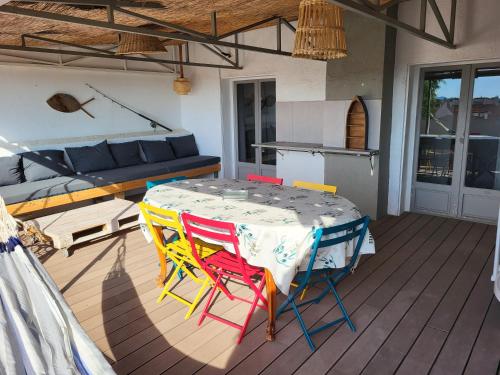 une table et des chaises sur une terrasse avec un canapé dans l'établissement Appartement au 2éme étage terrasse 30m2, à Saint-Cyprien