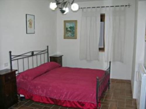 a bedroom with a bed with a red bedspread at Appartamenti In Villa Elena in Grutti