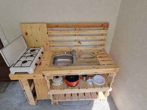 a wooden kitchen with a sink and a stove at GLAMPING HOUSE ˇVITAˇ in Tolmin