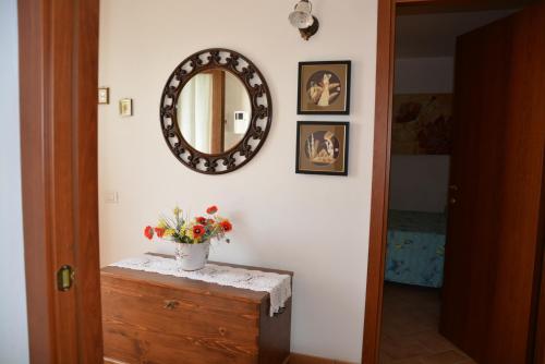 a hallway with a mirror and a vase of flowers on a dresser at Nonna Alda in Spoleto