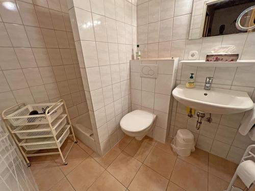 a white bathroom with a toilet and a sink at Ferienwohnung Wagner in Bergen