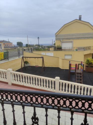 un balcone di un edificio con un parco giochi di Apartamento Tamarisco a Foz