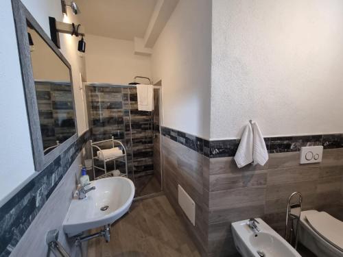 bagno con lavandino, servizi igienici e specchio di Suite Cornelia a Santa Teresa di Gallura