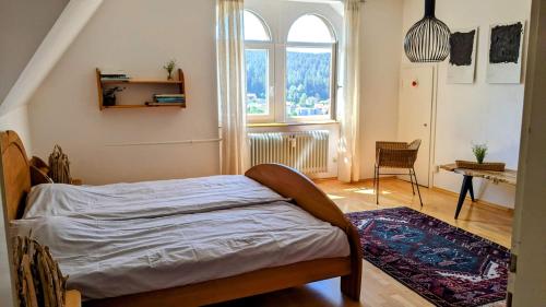 - une chambre avec un lit et une grande fenêtre dans l'établissement Klostereck (Villa C. Haas), à Sankt Georgen im Schwarzwald