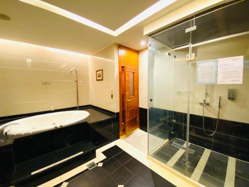 a bathroom with a tub and a shower and a sink at Holland Hill Motel in Tainan
