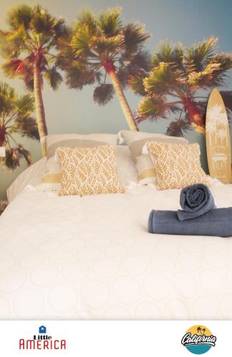 - une chambre avec un lit recouvert de palmiers dans l'établissement Little America - Appart Hôtel 3km Futuroscope, à Jaunay-Clan