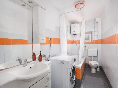 La salle de bains est pourvue d'un lavabo et d'un lave-linge. dans l'établissement Hanna Cozy Old Stone House, à Murter