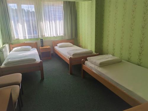 a room with three beds in a room at Hotel Slodes in Belgrade